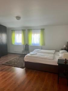 a bedroom with a bed with green curtains and a rug at Hotel Sport Mlada Boleslav in Mladá Boleslav