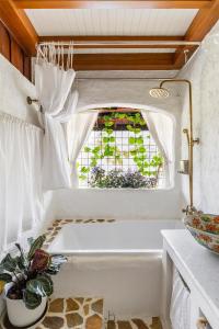 a bath tub in a bathroom with a window at Naturetalk Homestay in Ban Don