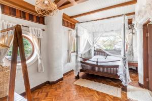 a bedroom with a canopy bed and a window at Naturetalk Homestay in Ban Don
