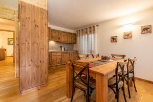 a kitchen and dining room with a wooden table and chairs at Maison La Louche - Courmayeur in Courmayeur