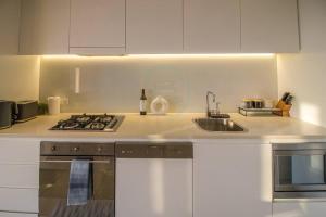 a kitchen with a sink and a stove at ZEN BY THE OCEAN - 1-BR Executive Biz Retreat in Darwin