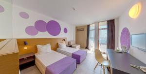 una camera d'albergo con letto e scrivania di Hotel Sunrise Golden Sands a Golden Sands