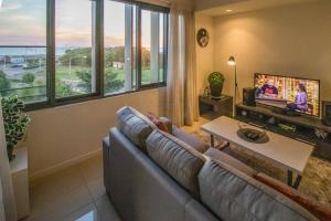 a living room with a couch and a tv at ZEN BY THE OCEAN - 1-BR Executive Biz Retreat in Darwin