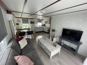 a living room with a couch and a flat screen tv at 08, ontdek het bosrijke Oisterwijk met het grootste terras van Nederland! in Oisterwijk
