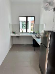 a kitchen with a refrigerator and a counter with a window at Inderaloka Villa 23B Free Parking in Shah Alam
