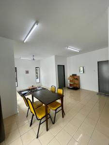 uma sala de jantar com uma mesa e cadeiras amarelas em Inderaloka Villa 23B Free Parking em Shah Alam