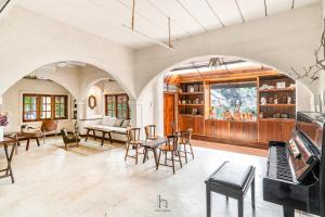 an open living room with a piano and chairs at Naturetalk Homestay in Ban Don