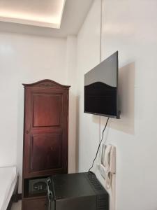 een kamer met een tv aan een muur met een printer bij MJ Pension House in Talisay