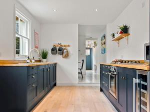 uma cozinha com armários azuis e uma bancada em Limewood Newly Renovated High End Home by the Sea em Whitstable