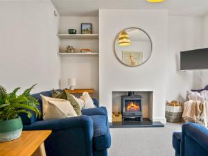 sala de estar con sofás azules y chimenea en Limewood Newly Renovated High End Home by the Sea en Whitstable