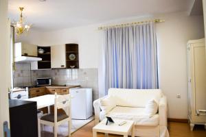 ein Wohnzimmer mit einer weißen Couch und einer Küche in der Unterkunft Apartments Diva in Sarajevo