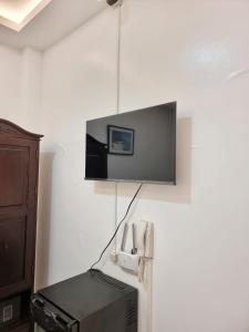 a tv hanging on a wall with a printer at MJ Pension House in Talisay