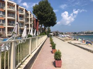 a sidewalk next to a beach with chairs and umbrellas at VP Bellevue in Ravda