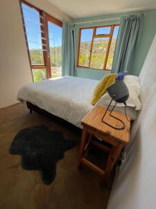 ein Schlafzimmer mit einem Bett und einem Tisch mit einer Lampe in der Unterkunft Starry Starry Night in Montagu