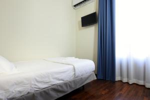 um quarto com uma cama branca e uma janela em Hotel Roma 62 em Palermo