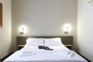 Una cama con sábanas blancas y toallas. en Hotel Roma 62 en Palermo