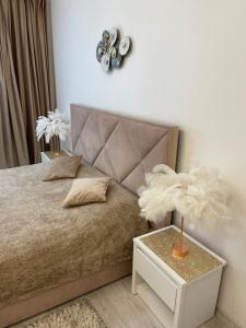 a bedroom with a bed and a nightstand with a white table at V&G Apartment in Lviv