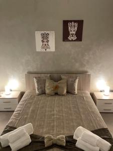 a bedroom with a large bed with two night stands at La Pietra di Giada in Syracuse
