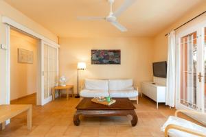 sala de estar con sofá blanco y TV en Illes Medes a el Golfet en Palafrugell