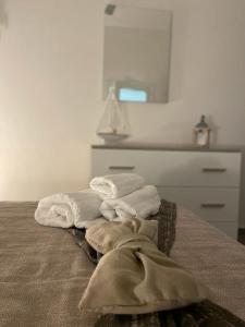 una pila de toallas sentadas encima de una cama en La Pietra di Giada en Siracusa