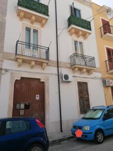 una macchina blu parcheggiata di fronte a un edificio di La Pietra di Giada a Siracusa