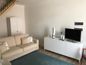 a living room with a couch and a flat screen tv at Cielo Apartment in Forlì