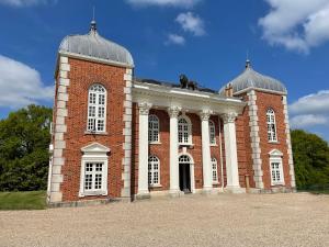 un edificio de ladrillo con dos cúpulas encima en Eastwood Observatory: 12 bedrooms, swimming pool and tennis court en Hailsham