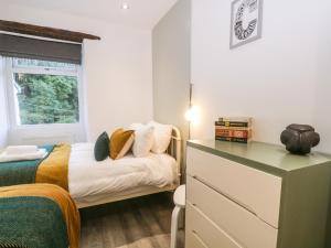 a small bedroom with a bed and a window at Turn Cottage in Ulverston