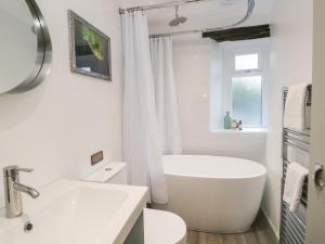 a white bathroom with a tub and a sink at Turn Cottage in Ulverston +16 photos