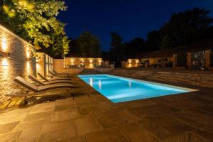a swimming pool in a backyard at night at Eastwood Observatory: 12 bedrooms, swimming pool and tennis court in Hailsham