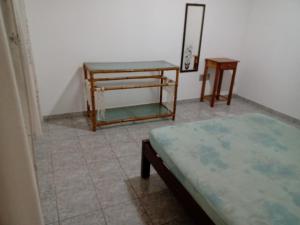 Zimmer mit 2 Tischen, einem Bett und einem Spiegel in der Unterkunft Sobrado no litoral norte de são Sebastião in São Sebastião