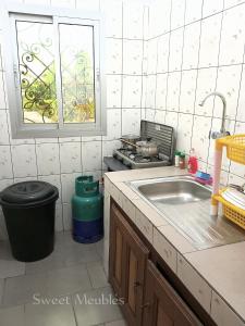 a kitchen with a sink and a stove at Studio meublé Yaoundé Ekounou in Yaoundé