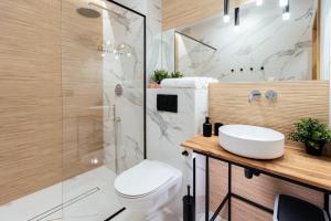 La salle de bains est pourvue d'une douche, de toilettes et d'un lavabo. dans l'établissement Jaśmin Apartamenty, à Krynica-Zdrój