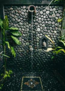 a bathroom with a wall covered in rocks at Chez Bisma in Sidemen