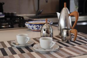 a kitchen counter with two cups and a tea kettle at Antura in Pantelleria