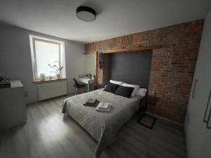 a bedroom with a bed and a brick wall at Apartament Centrum Bodzentyńska in Kielce