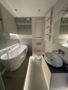 a white bathroom with a tub and a sink at Apartament Centrum Bodzentyńska in Kielce