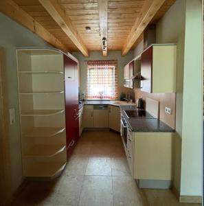 een kleine keuken met een koelkast en een raam bij Ferienhaus Stefanie in Bernbeuren