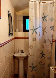 a bathroom with a sink and a shower curtain at Casa del Águila del Valle in Riópar Viejo