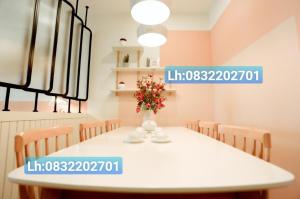 a dining room with a white table with a vase of flowers at TMS Pullman Căn Hộ Cao Cấp Quy Nhơn in Quy Nhon