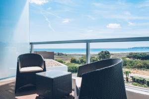 a balcony with chairs and a view of the ocean at Iberostar Selection Lagos Algarve in Lagos