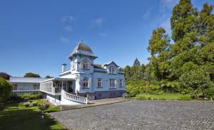 uma grande casa azul com uma torre de relógio em PortoBay Serra Golf em Santo da Serra