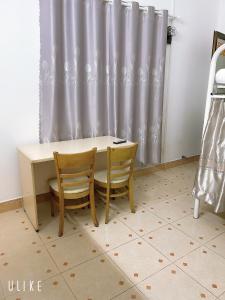a table and two chairs in a room with a curtain at Saigon Cozy House & coffee in Ho Chi Minh City
