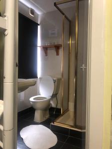 a bathroom with a toilet and a glass shower at Ultimate Family Guest House in Blackpool