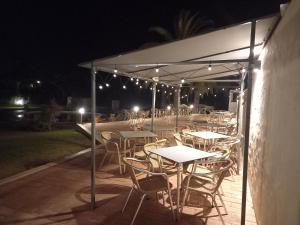 a group of tables and chairs under a canopy at night at Vilamar in Luz