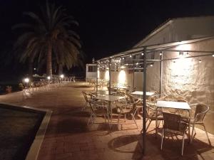 a patio with tables and chairs at night at Vilamar in Luz
