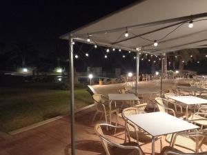 a group of tables and chairs under a tent at night at Vilamar in Luz