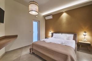 Un dormitorio con una cama grande con almohadas blancas. en El Platanias, en La Canea 14 fotos más