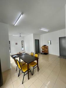 a dining room with a table and yellow chairs at Inderaloka Villa 23A Free Parking in Shah Alam