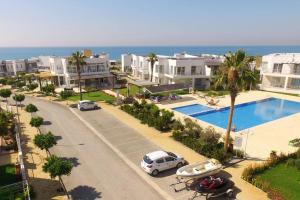 an aerial view of a house with a pool and cars at Двухкомнатные апартаменты в жилом комплексе Caesar Beach D1 Flat15 in Boğaz
